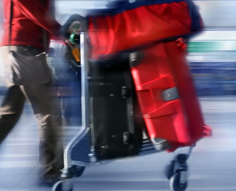 Gepäckwagen mit Koffern am Flughafen